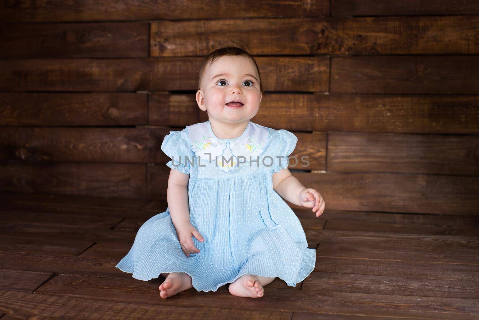 Beautiful girl in blue dress on wooden background