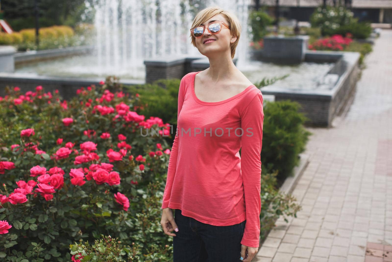 Beautiful girl in the Park. Blooming roses. Fountain by StudioPeace