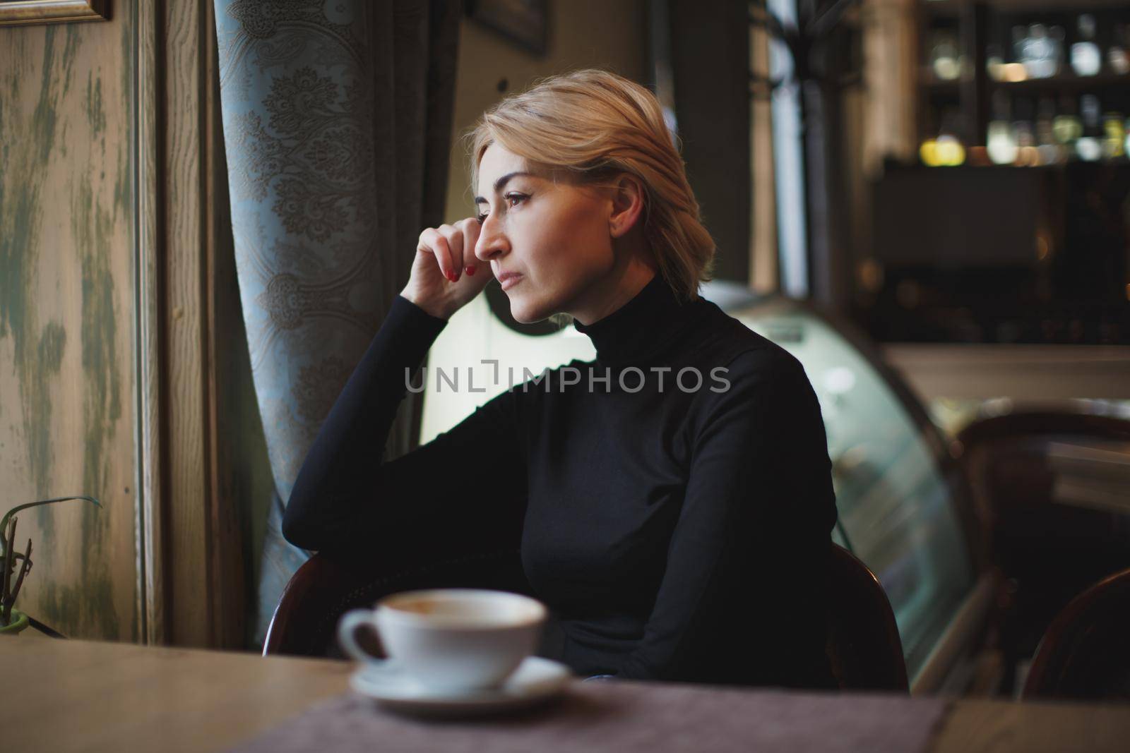 Beautiful woman drinking coffee in a cafe. by StudioPeace