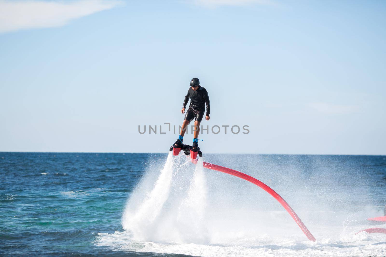 A rider on a flyboard in the ocean does difficult stunts. by StudioPeace
