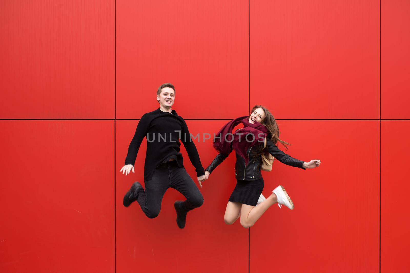 Jump. A man and a woman on a red background.