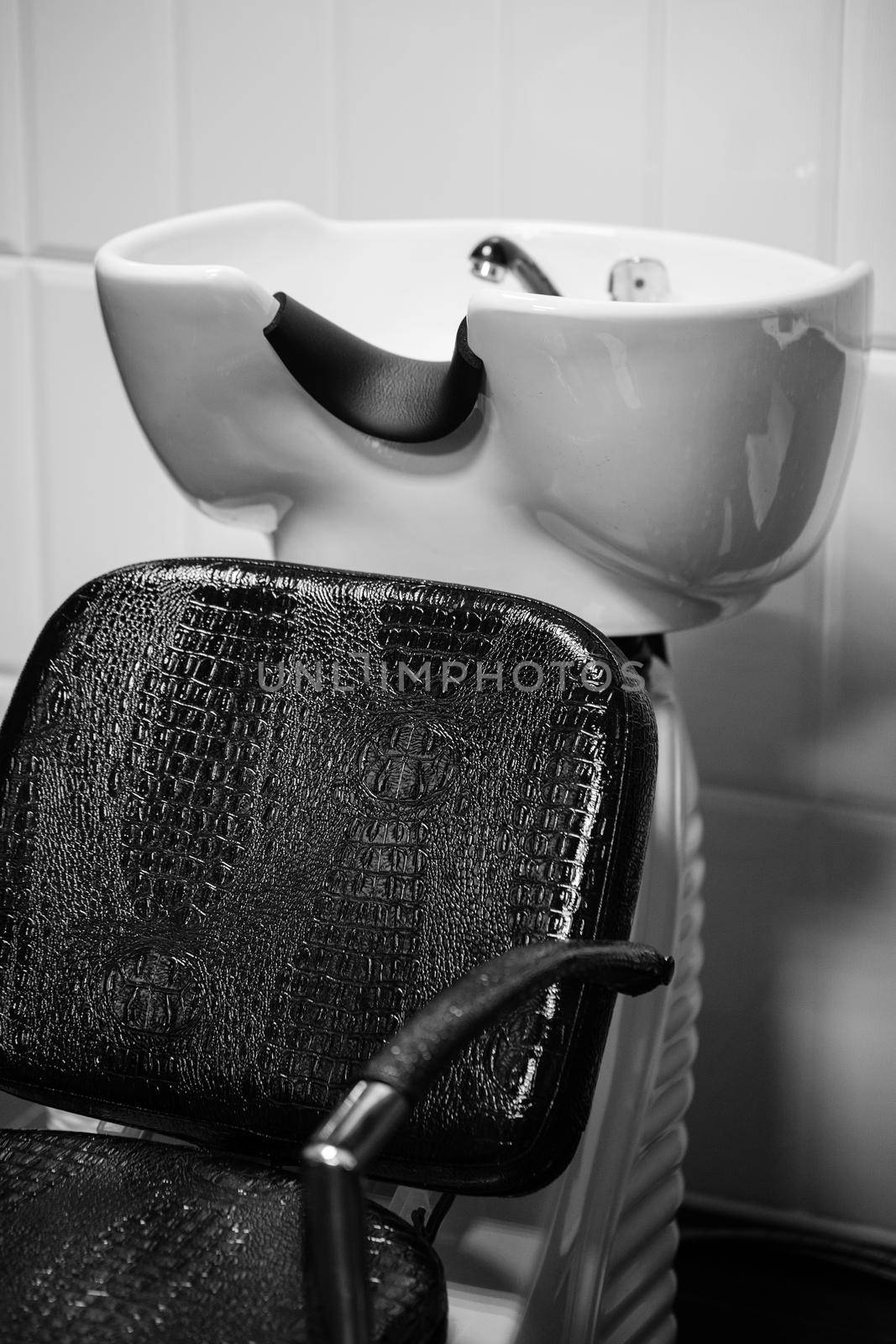 The black leather recliner next to the sink in the Barber shop. Black and white. by StudioPeace