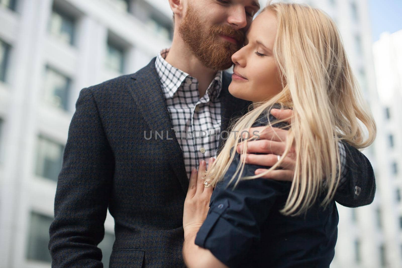 A young man embraces a girl in the city