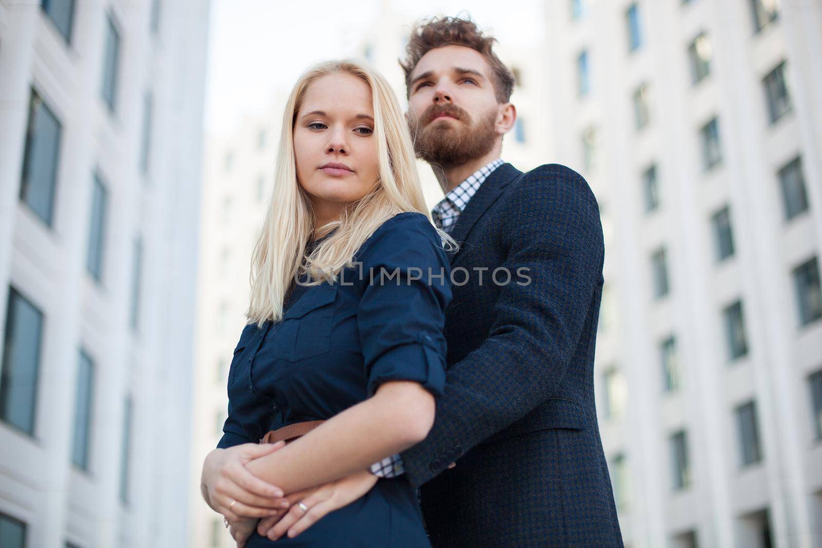 Man and woman hugging in the background is the building of the business center.