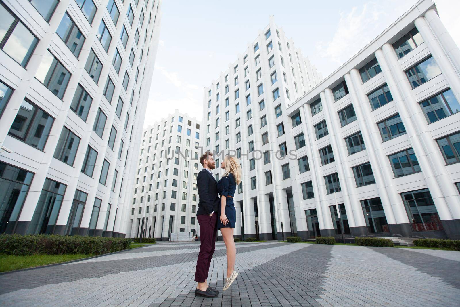 Man and woman hugging in the background is the building of the business center by StudioPeace