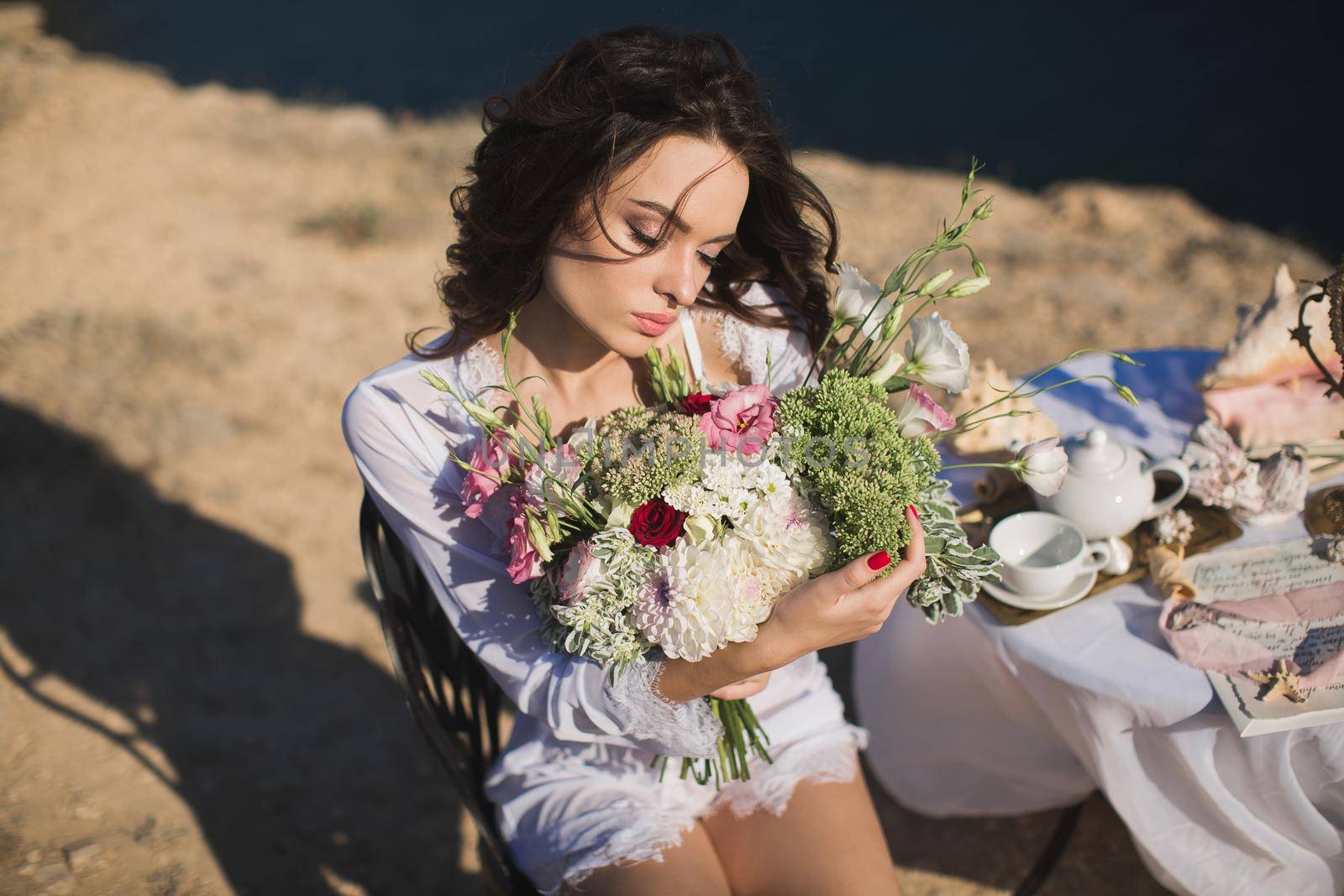 Bride in lingerie. Holds the Bridal bouquet . Charges of the bride, bride's morning.