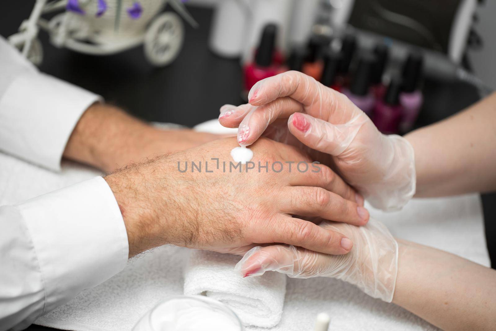 Hand massage after manicure. The girl puts the cream on the client's hands. by StudioPeace