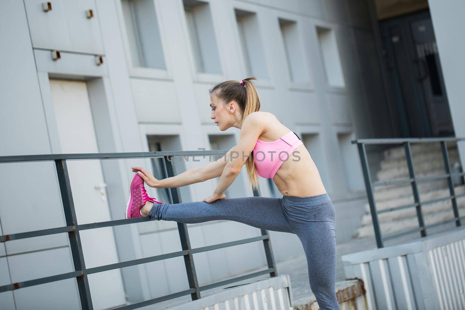 Fitness sport girl in fashion sportswear doing yoga fitness exercise in the street, outdoor sports, urban style. by StudioPeace
