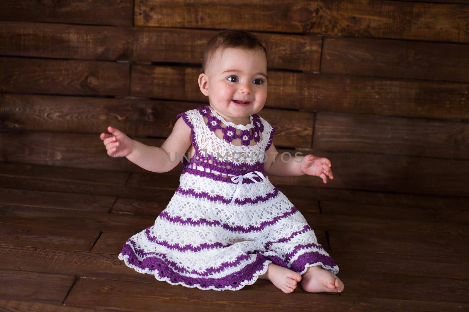 Beautiful girl in pink dress on a wooden background