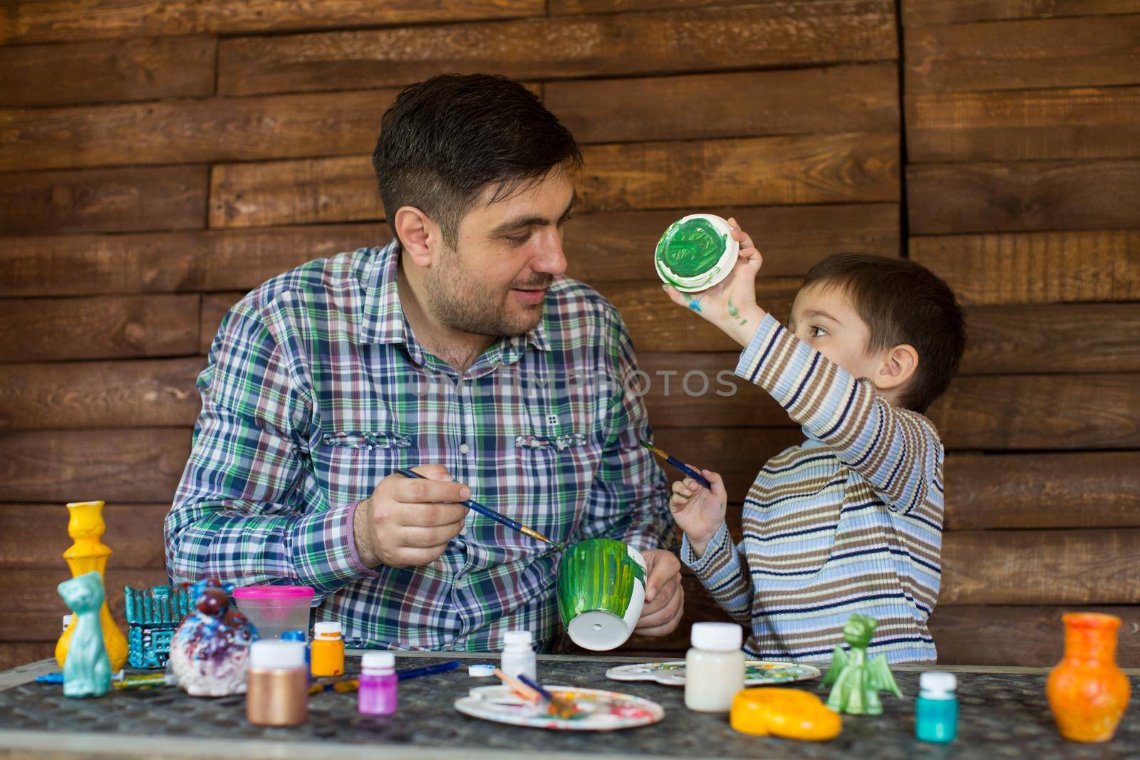 Portrait of a father and son who will decorate a vase by StudioPeace