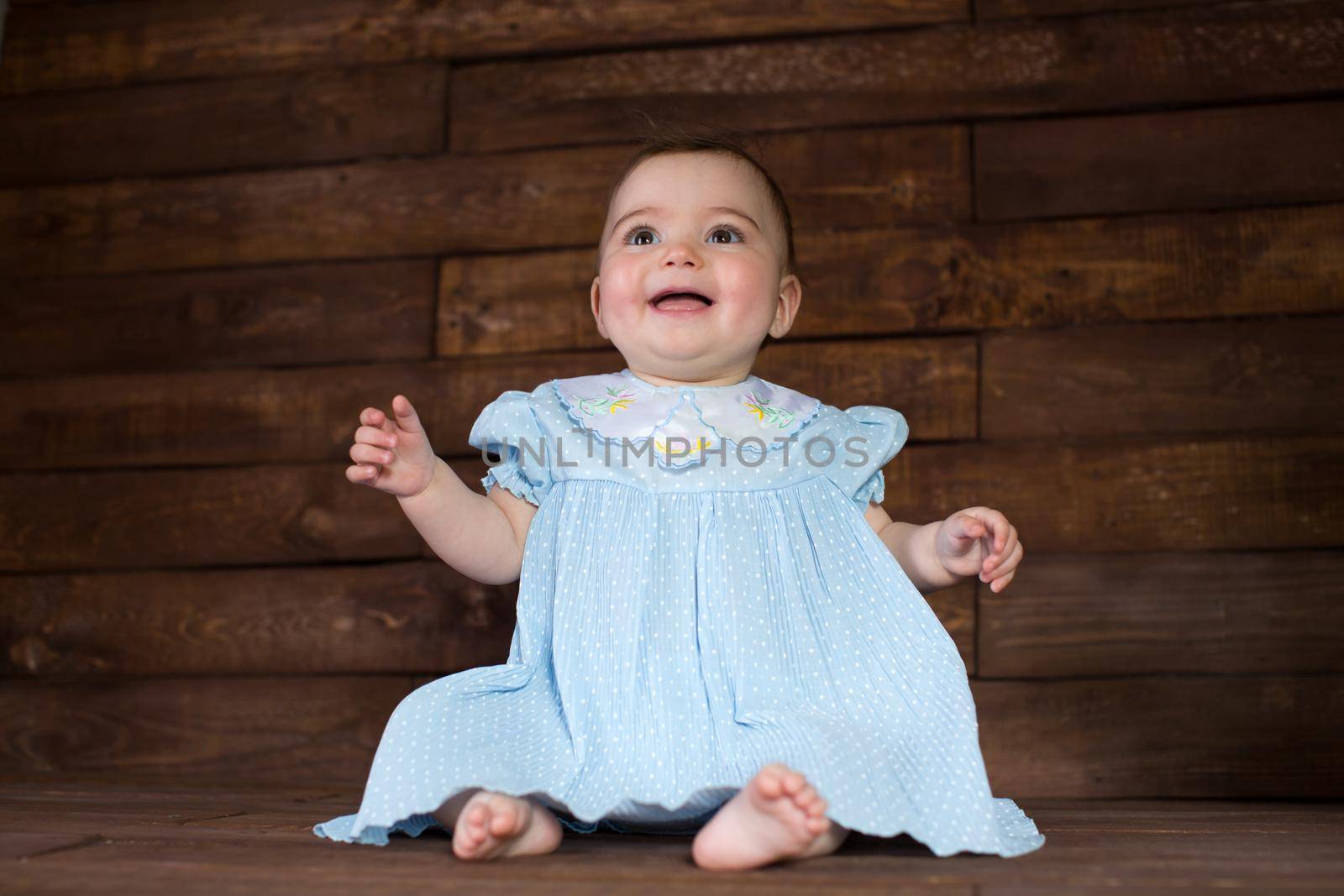 Beautiful girl in blue dress on wooden background