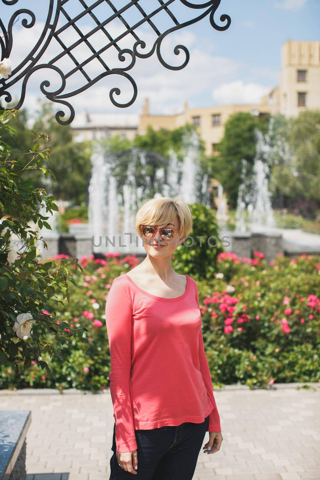 Beautiful girl in the Park. Blooming roses. Fountain.