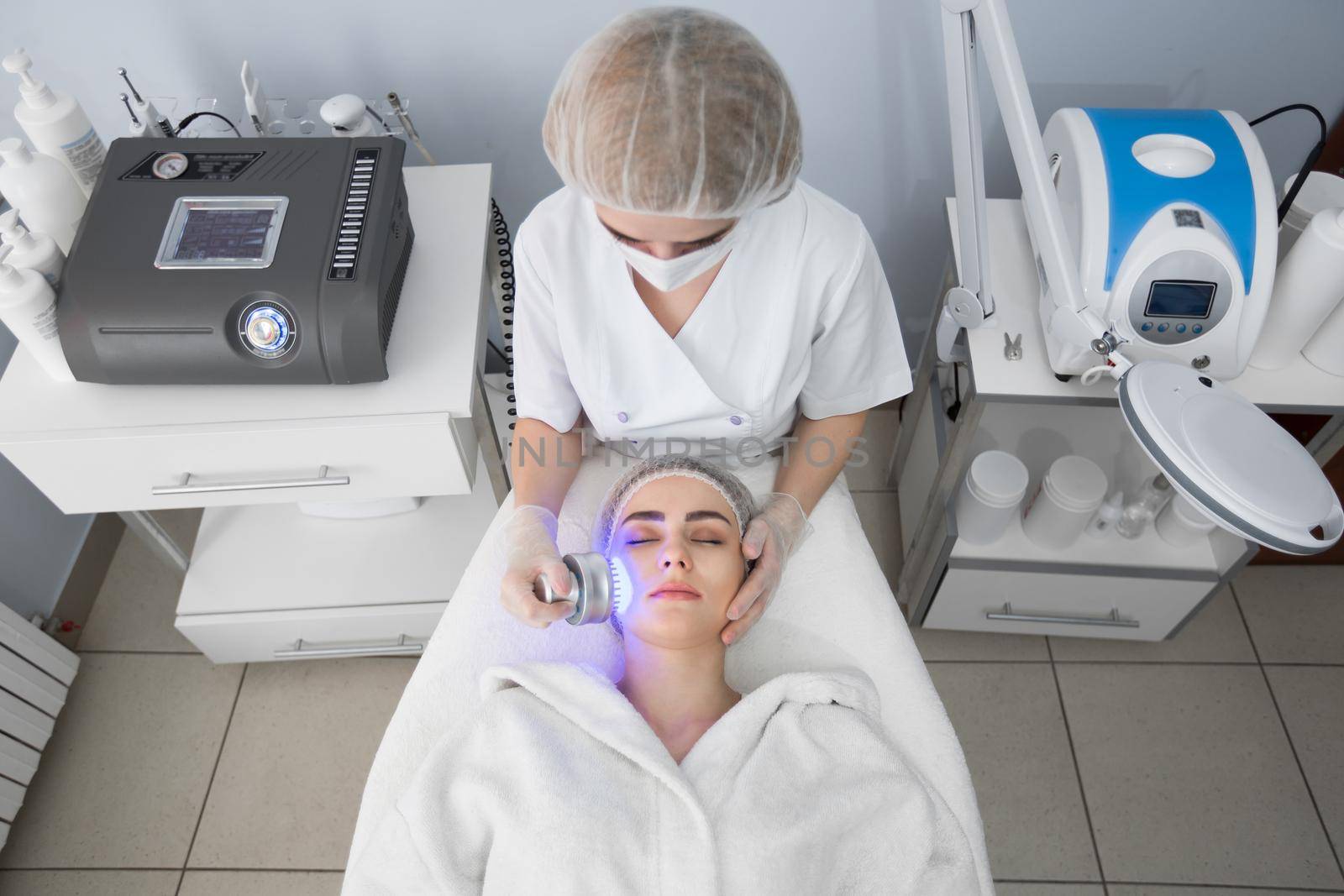 Ultrasonic massager. Light skin treatment, the woman in the beauty salon. by StudioPeace