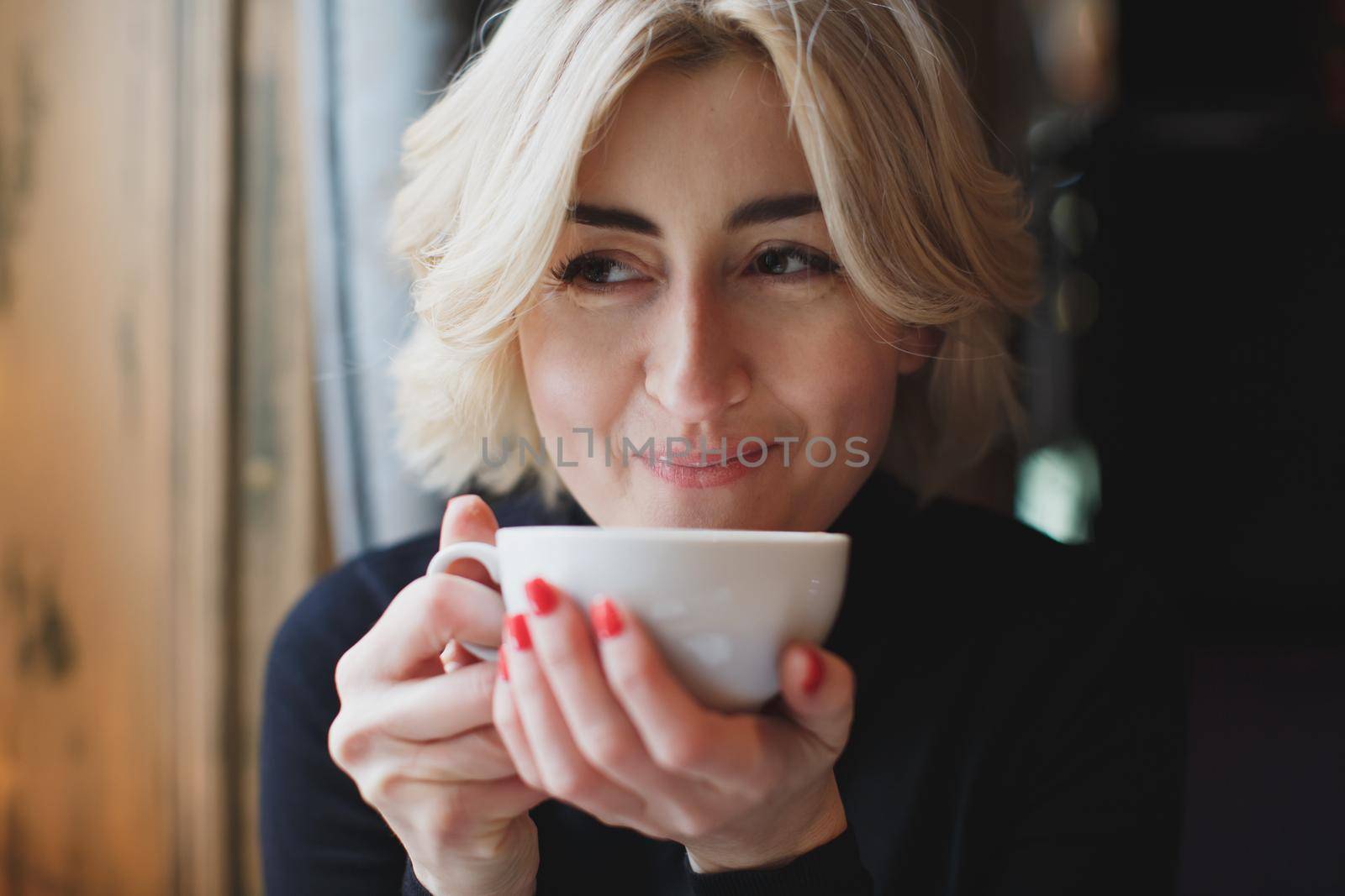 Beautiful woman drinking coffee in a cafe. by StudioPeace