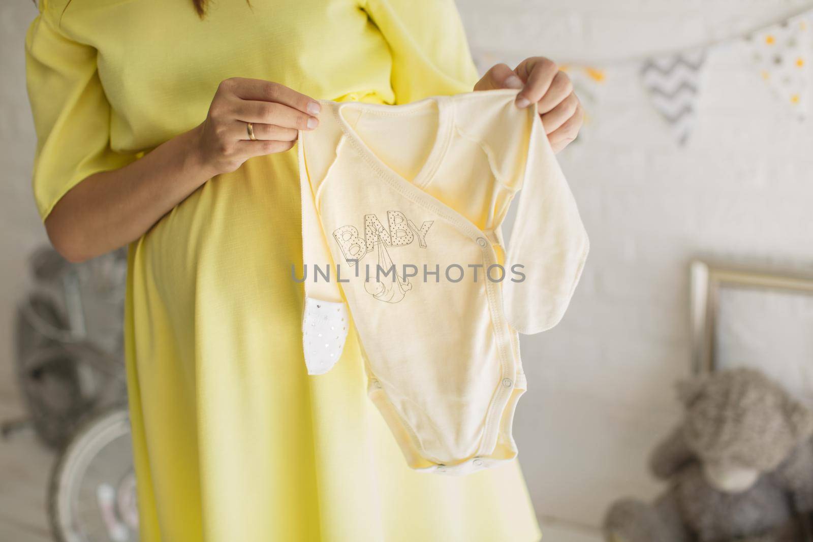 Beautiful pregnant woman in a yellow dress in the Studio.