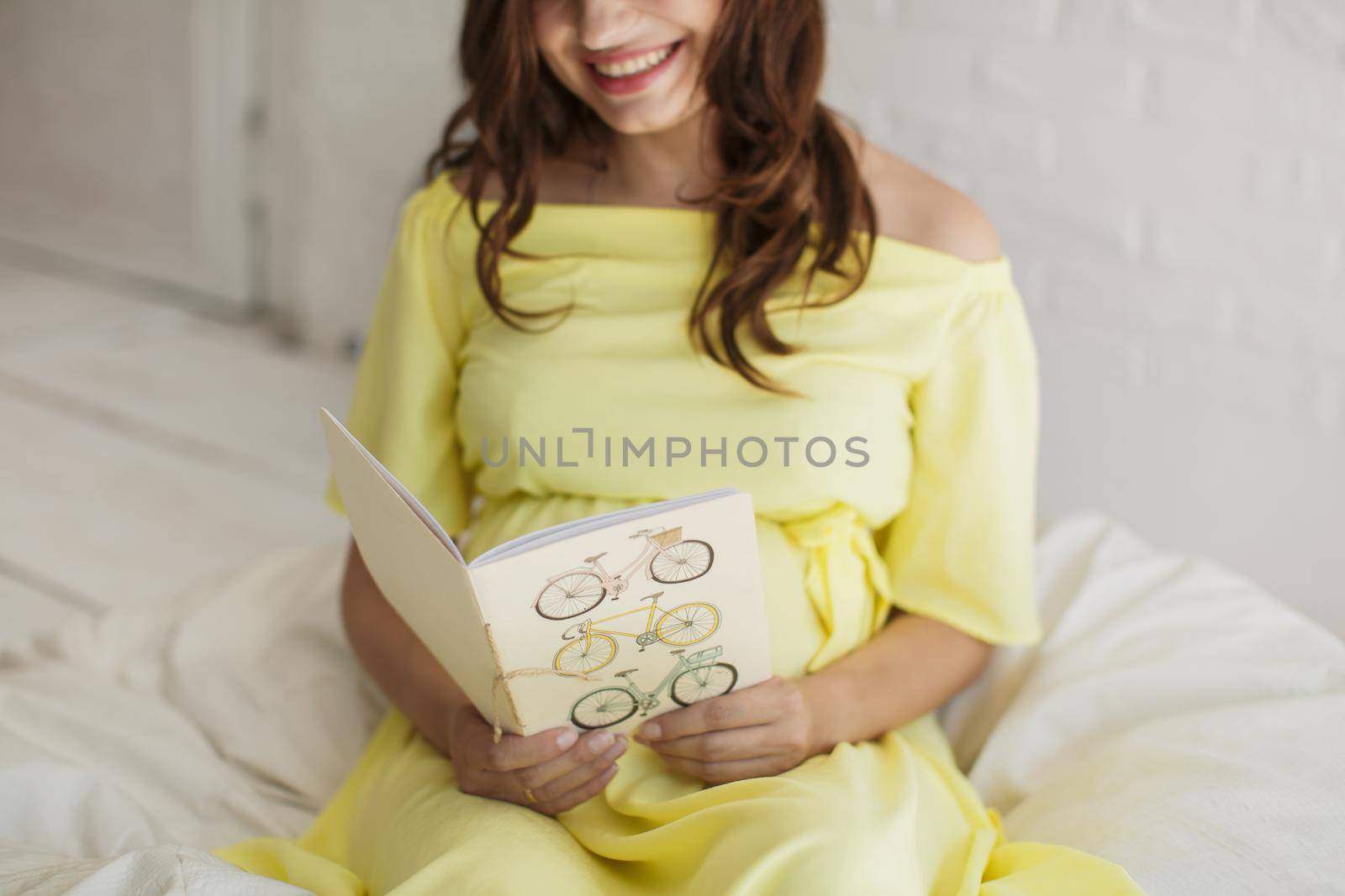 Beautiful pregnant woman in a yellow dress in the Studio.