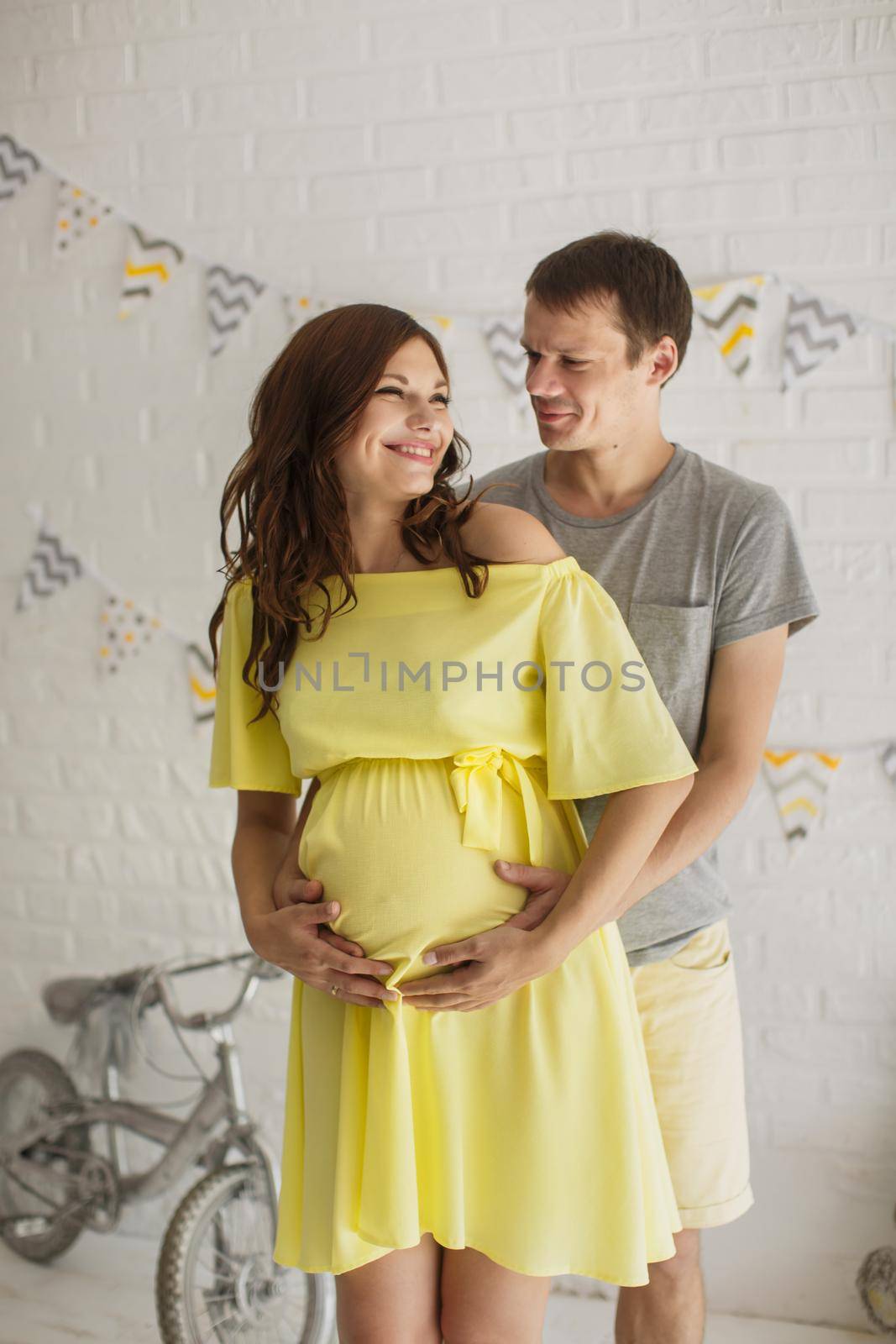 Waiting for baby. Happy man hugging his pregnant woman