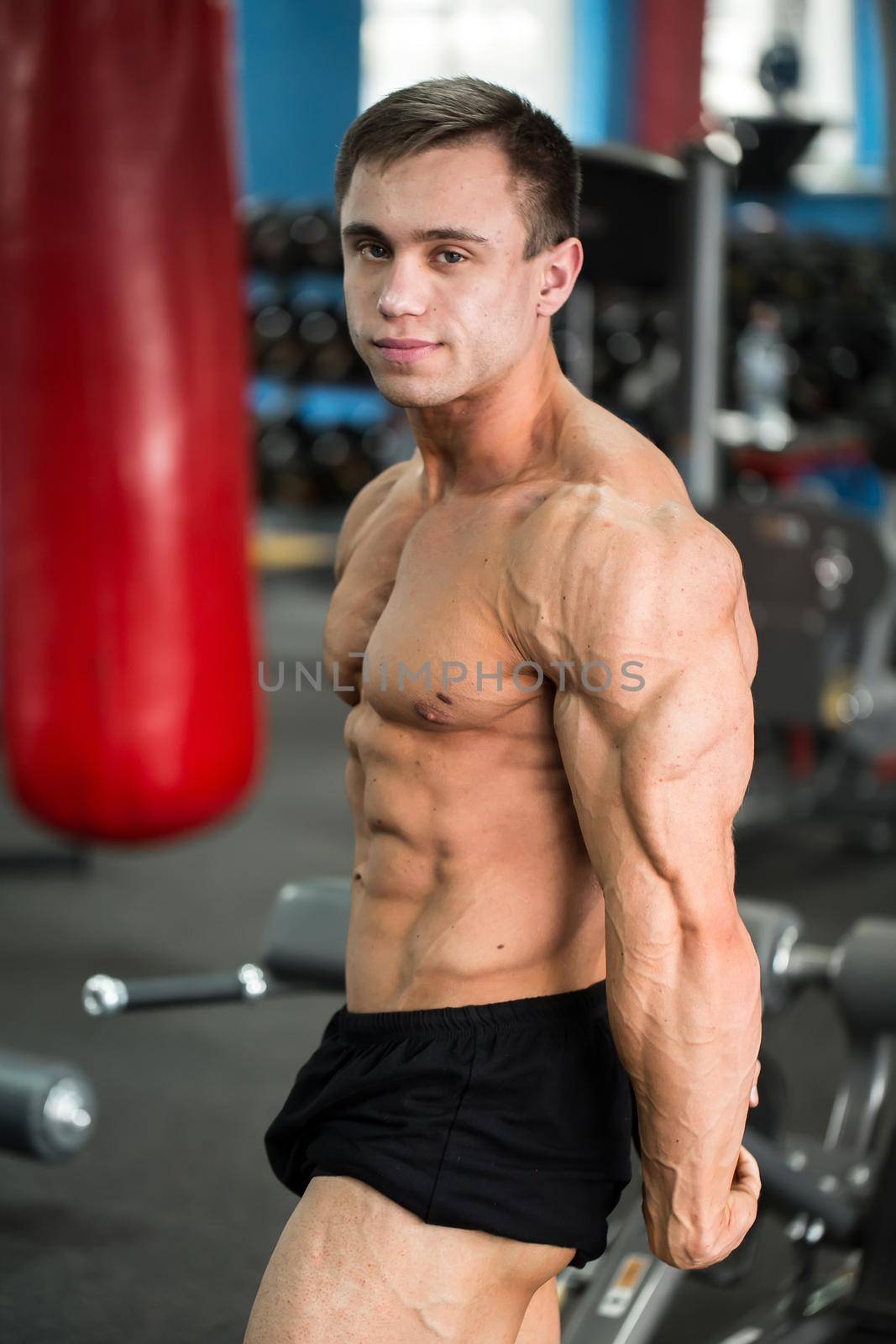 detail of a bodybuilder posing in the gym: side chest