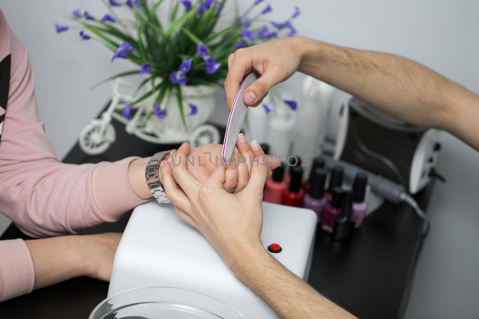 Woman in a nail salon receiving a manicure by a beautician