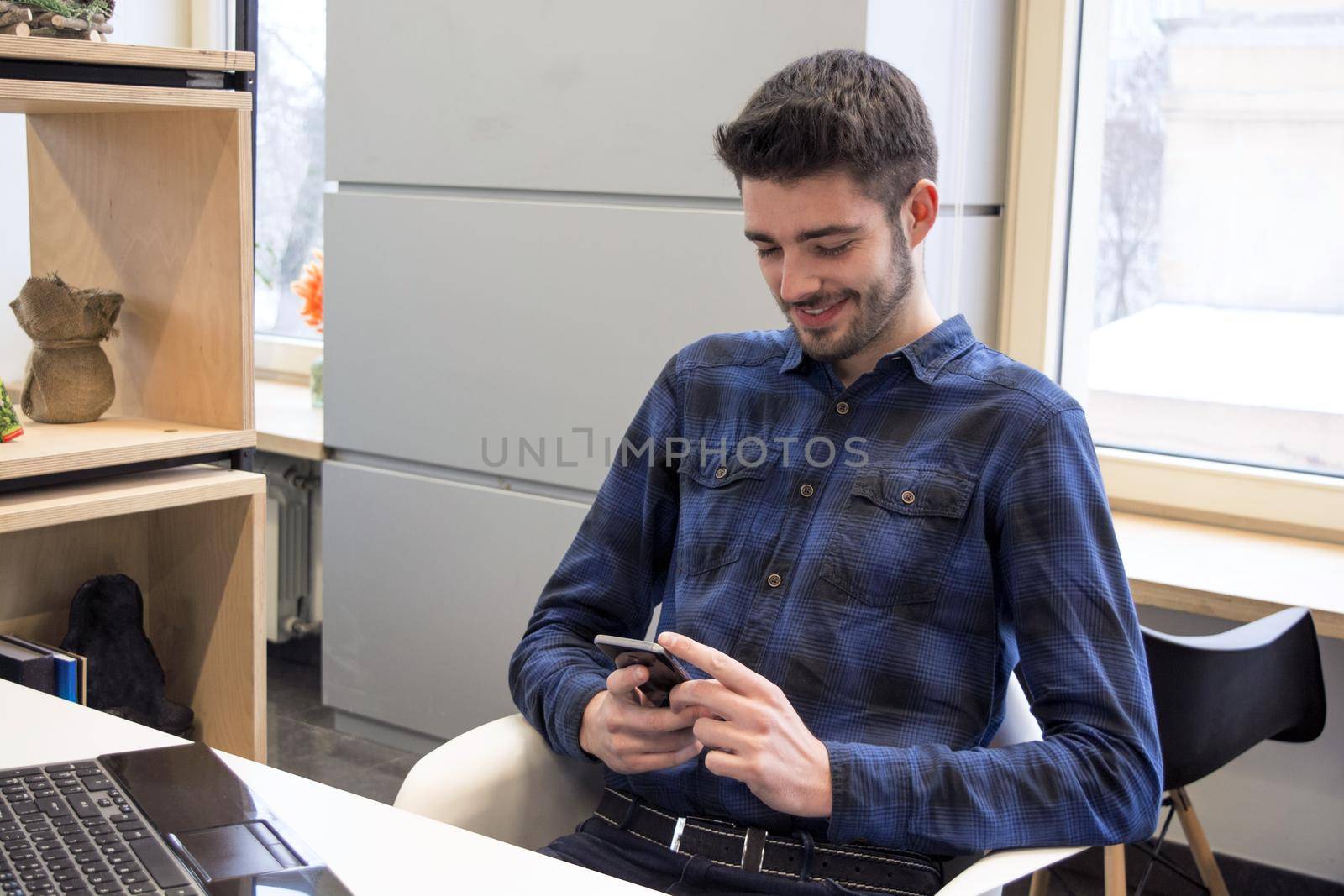 Happy freelancer employee communication concept. Technology web workspace. Coworking young man chatting. Smiling student at Digital library.