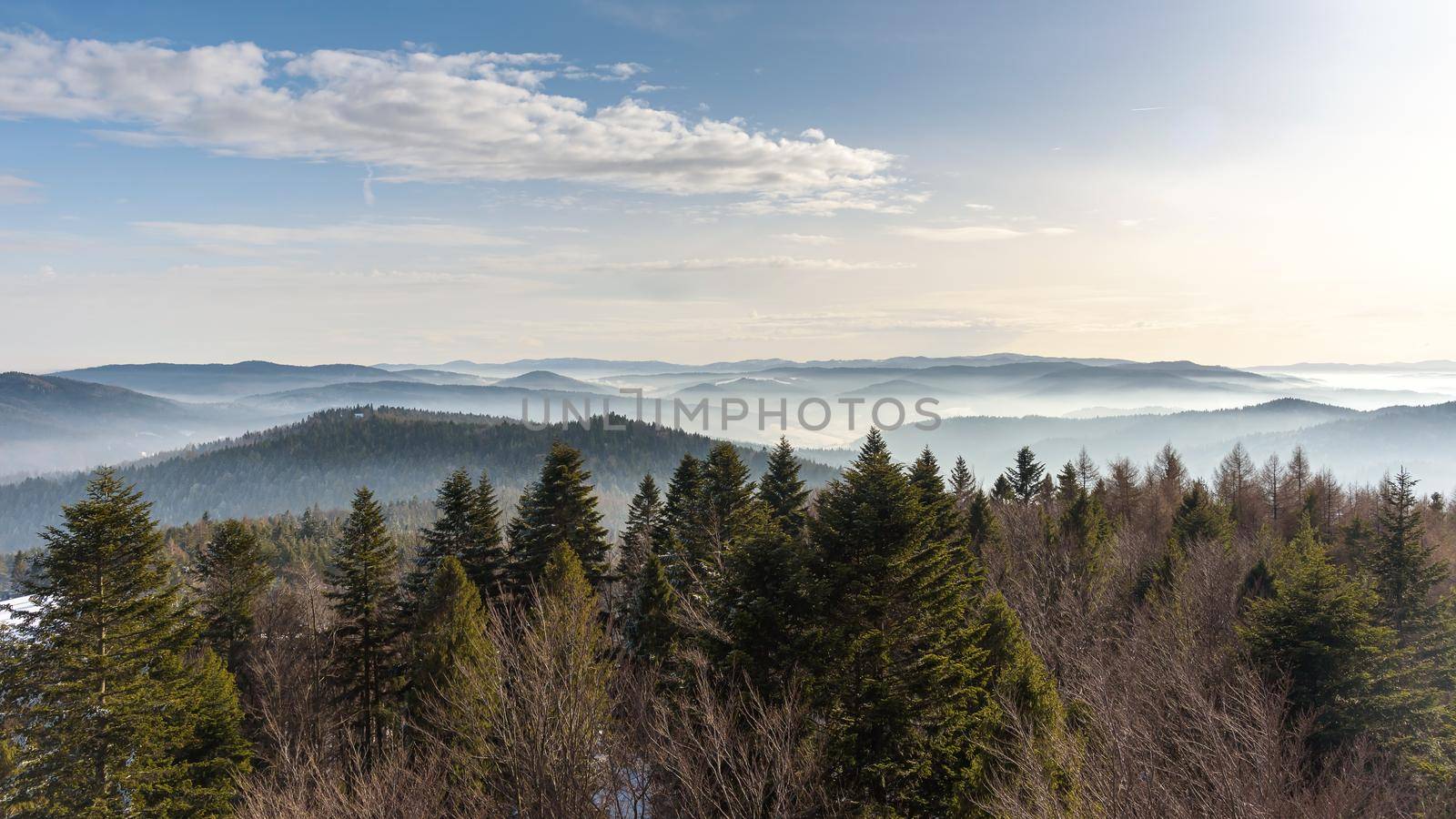 Foggy view of Beskid Sadecki mountain range in Poland on a sunny day