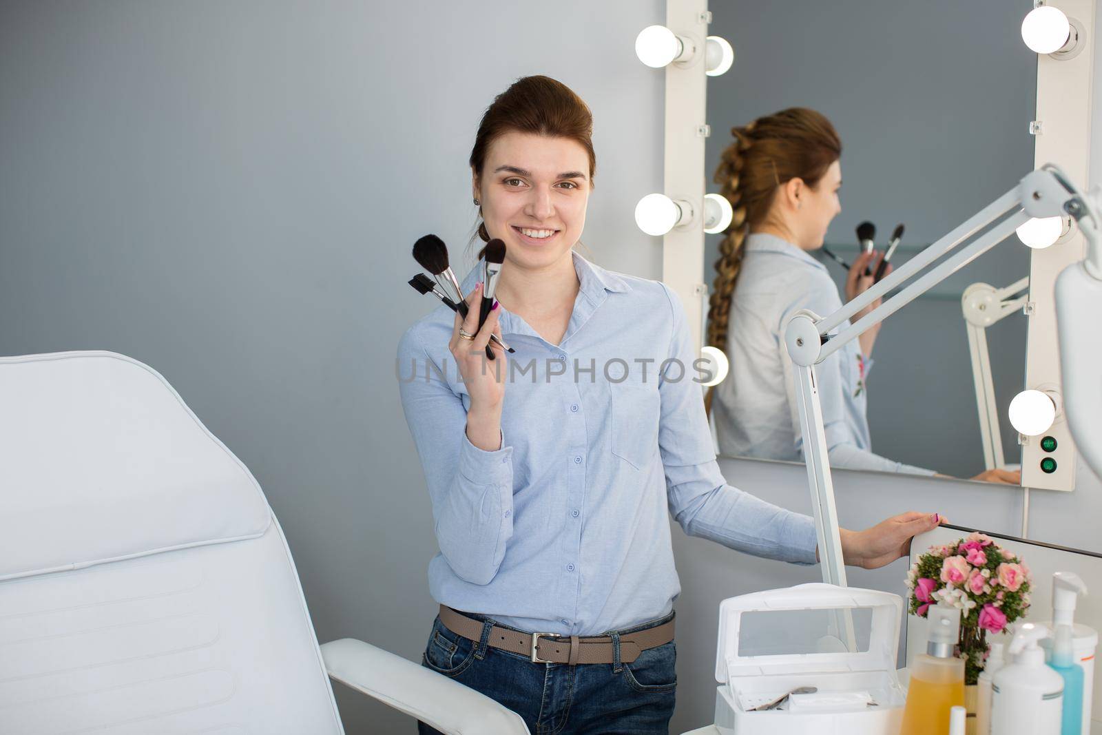 Girl artist with brush in hand near the mirror