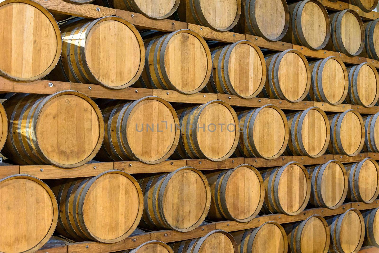 Lots of wooden barrels in the wine cellar