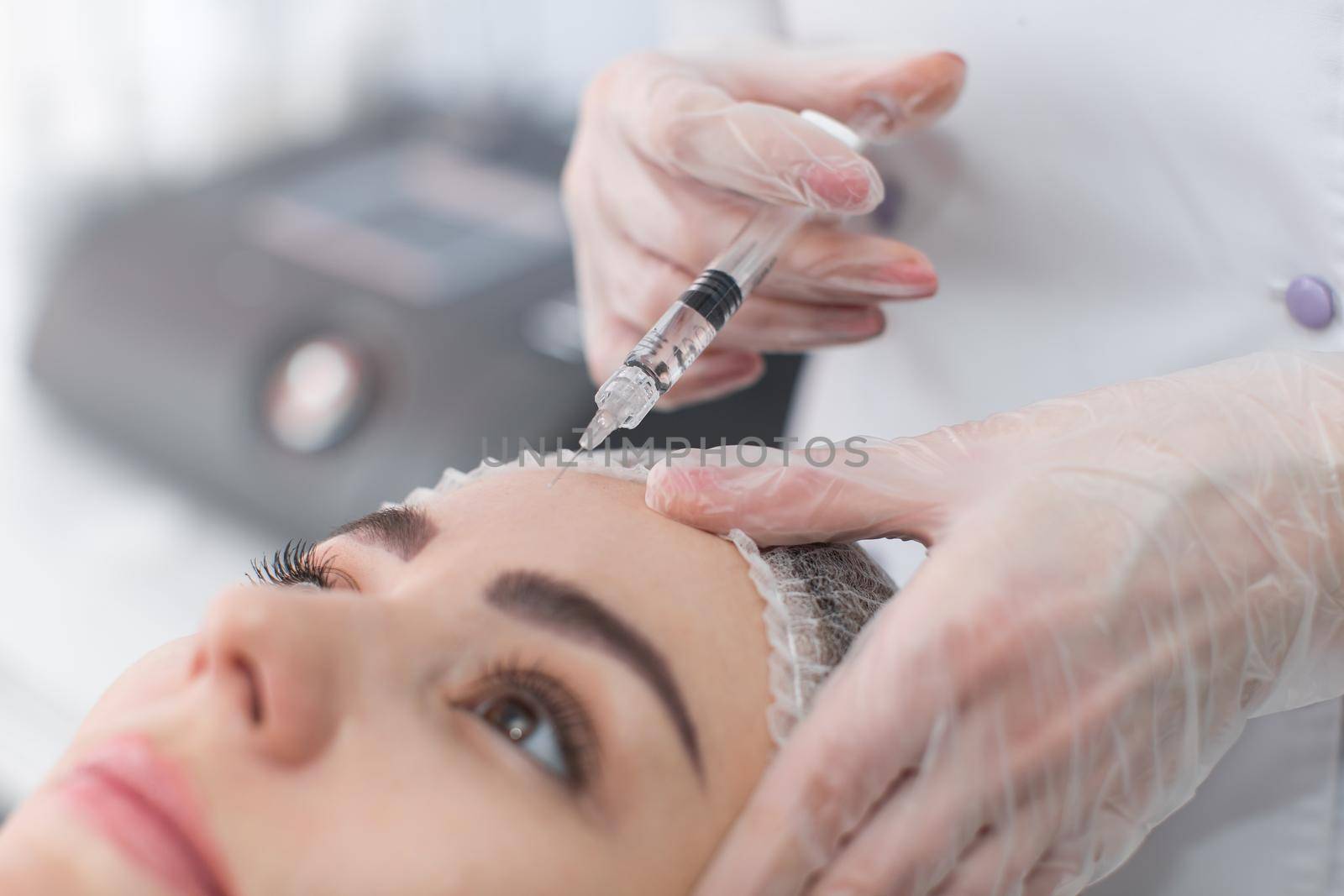 Woman gets injection in her face. Beauty woman giving botox injections. Young woman gets beauty facial injections in the cosmetology salon. Face aging injection. Aesthetic Medicine, Cosmetology