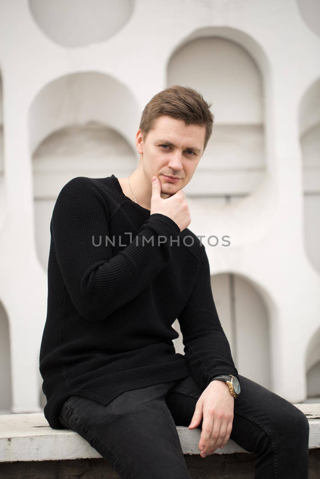 Fashion young man in black clothes on white wall background. by StudioPeace