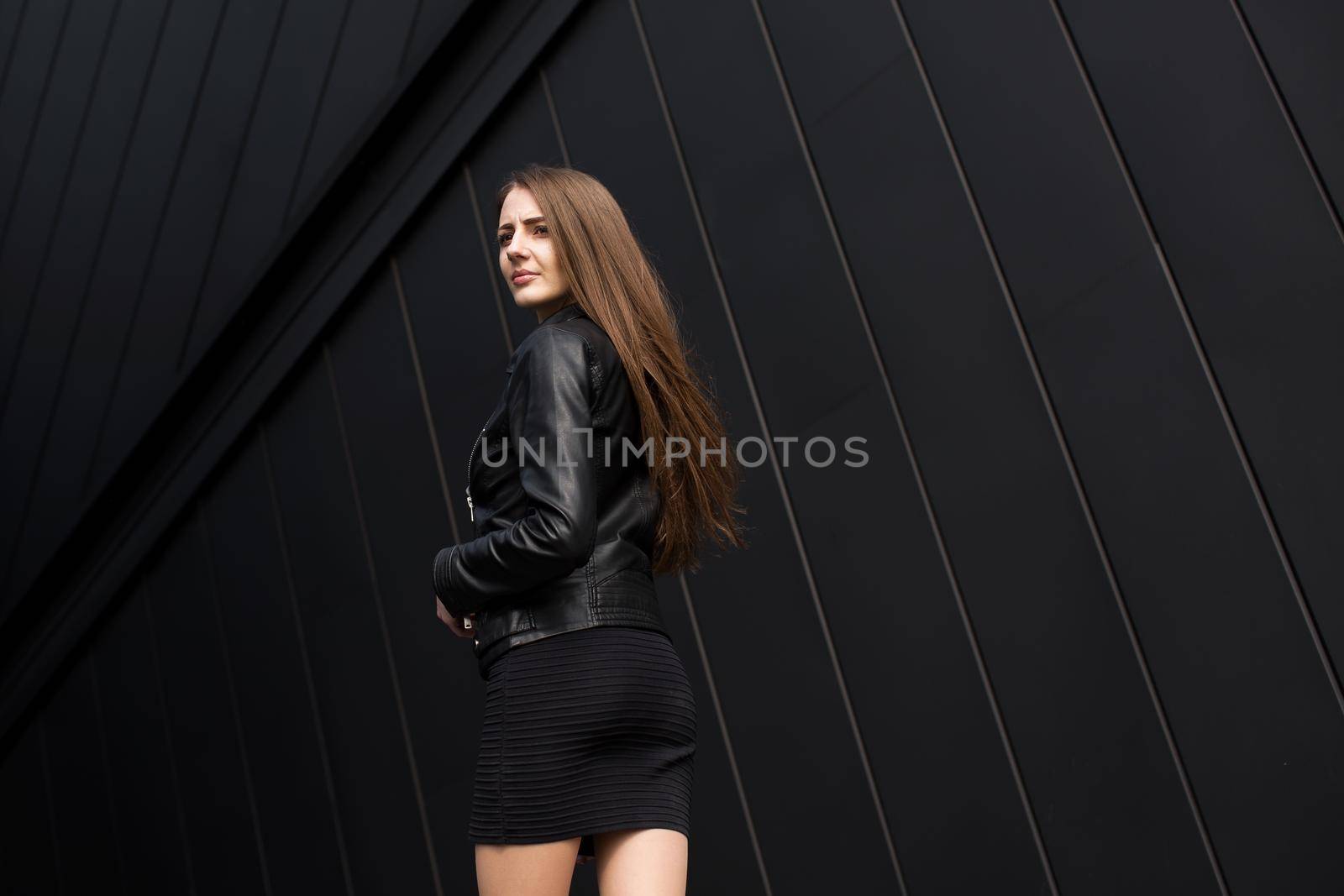 Fashion style photo of beautiful young woman on black background wall