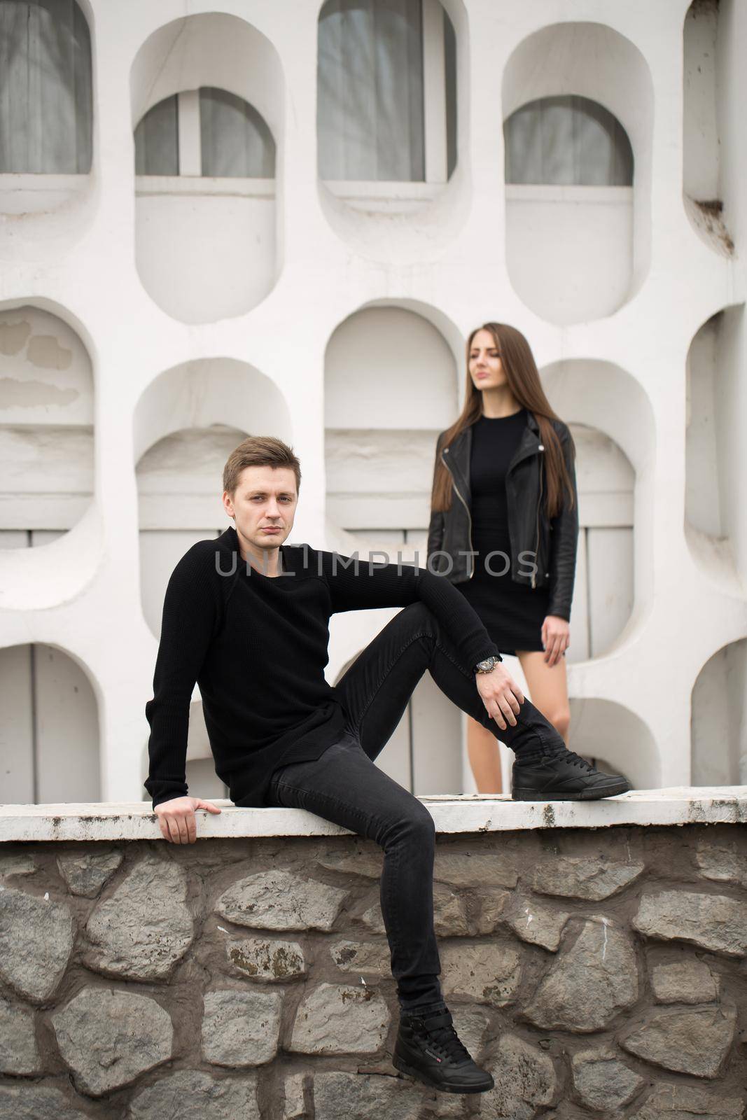 young sexy couple in black clothes posing with a background on the white wall. by StudioPeace