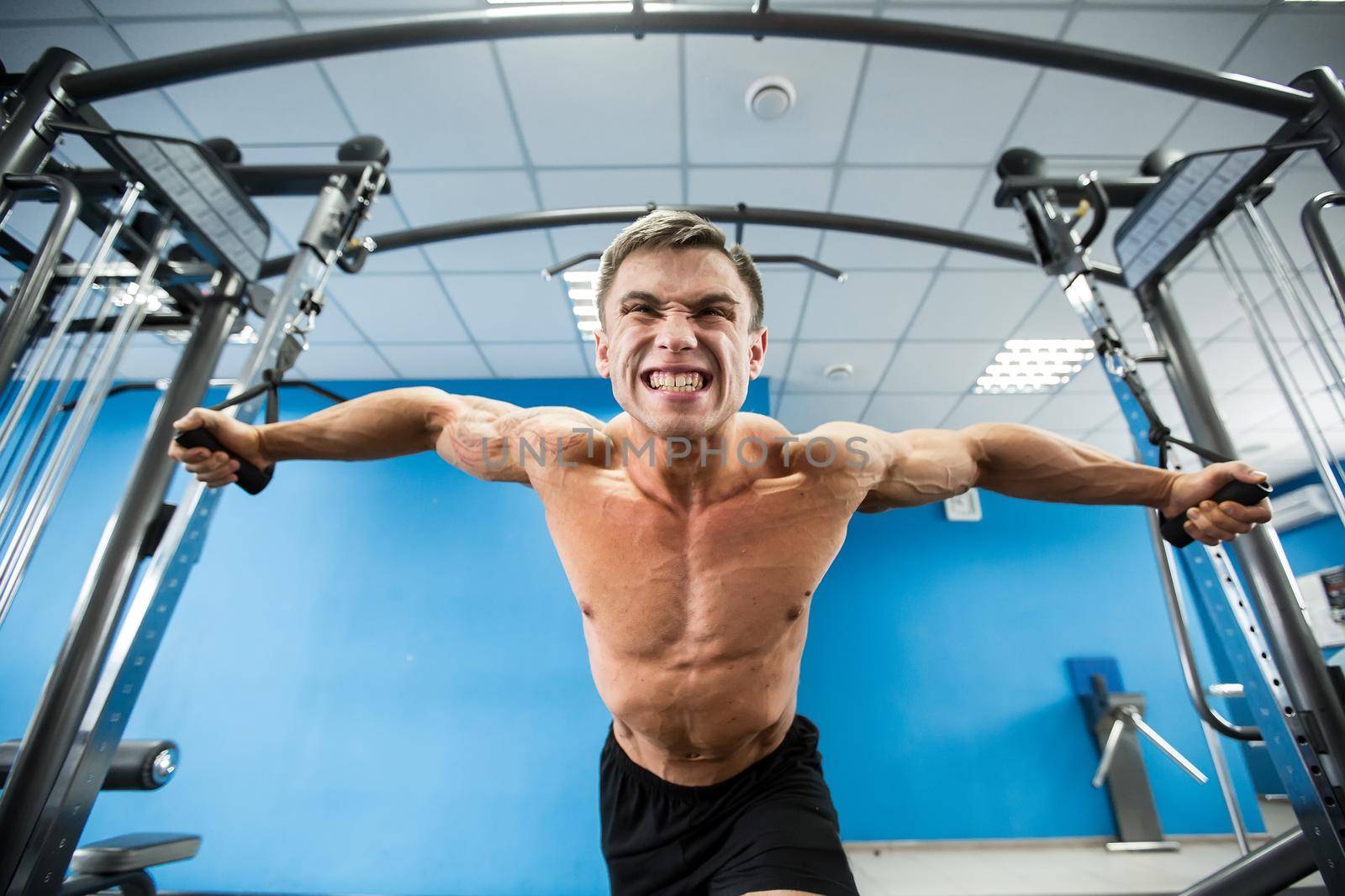 Young Bodybuilder Is Working On His Chest With Cable Crossover In Gym