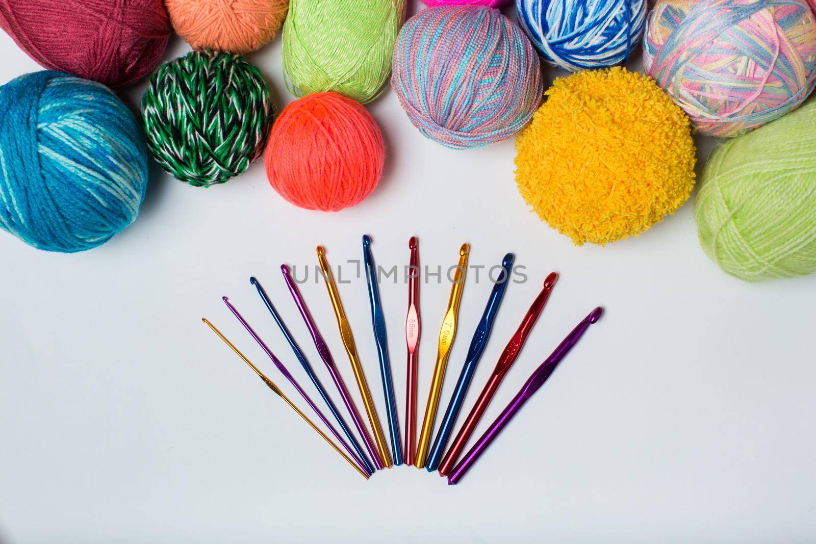 top view on white background with lots of balls of wool and knitting needles. by StudioPeace