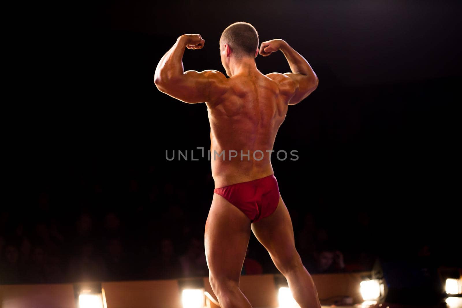 Bodybuilder, competition. Handsome muscular bodybuilder posing on Front Lat Spread by StudioPeace