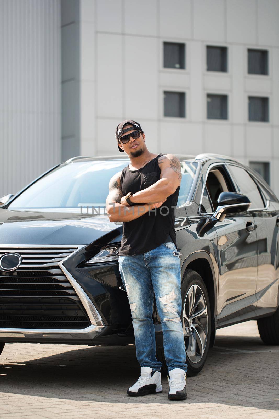 An African-American man poses near his car. by StudioPeace