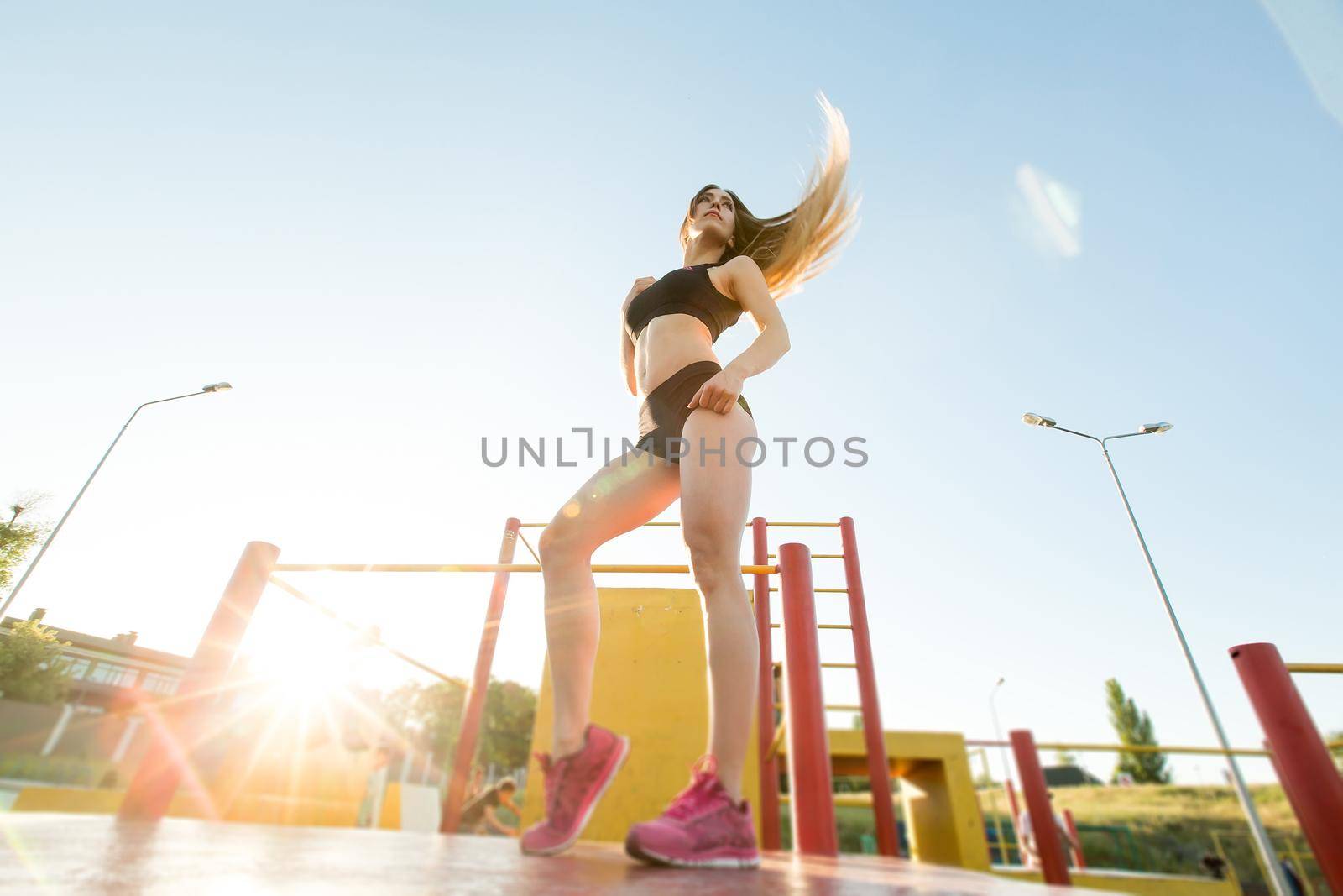 Beautiful girl posing on the playground at sunset