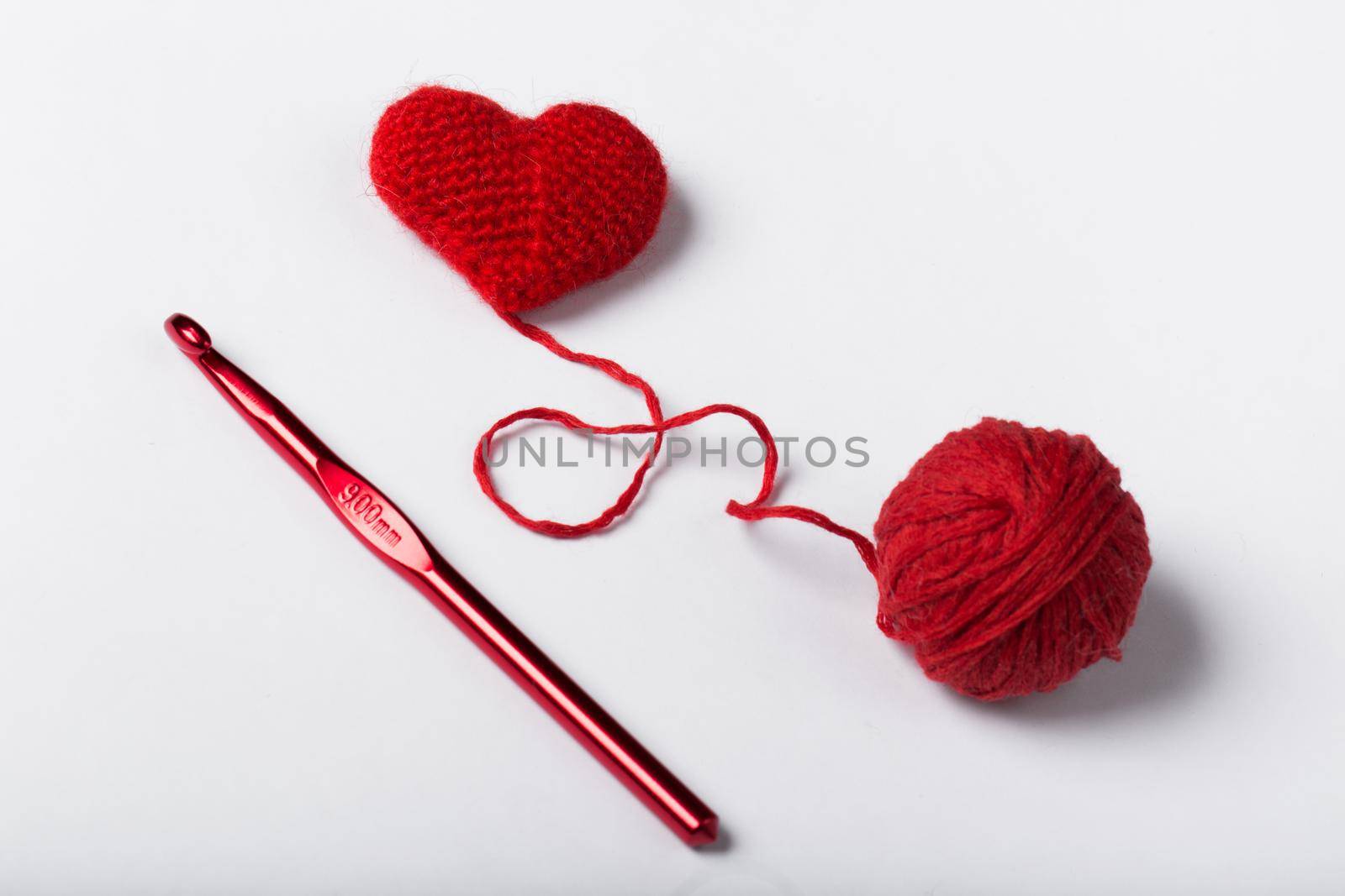 Close up of a wool ball and heart shape on white background. Heart shaped woolen yarn. Love Crochet. by StudioPeace