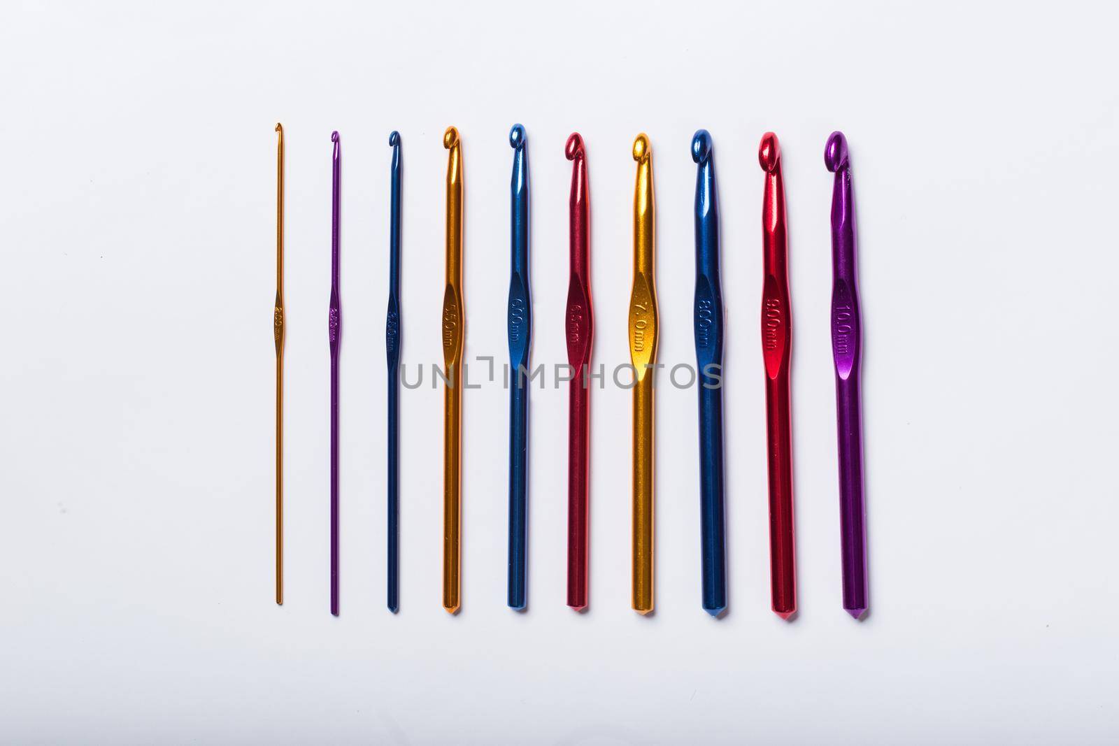 Colored hooks for wool knitting on white background