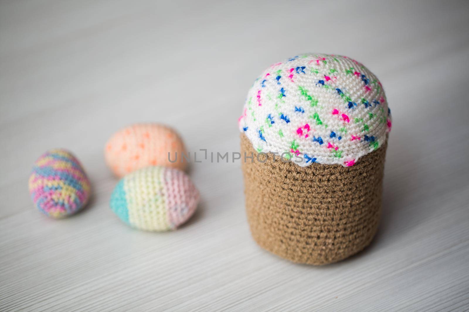 Knitted Easter eggs, chicken, cock on a white table