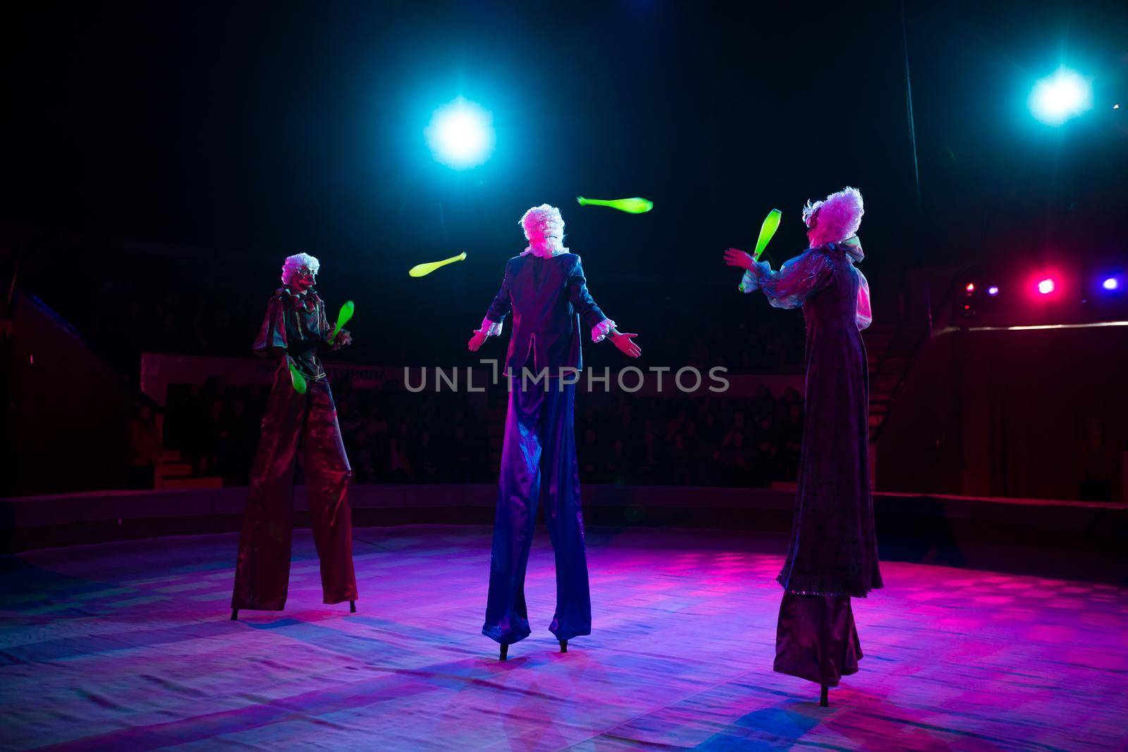 Jugglers in the circus. Clown on stilts