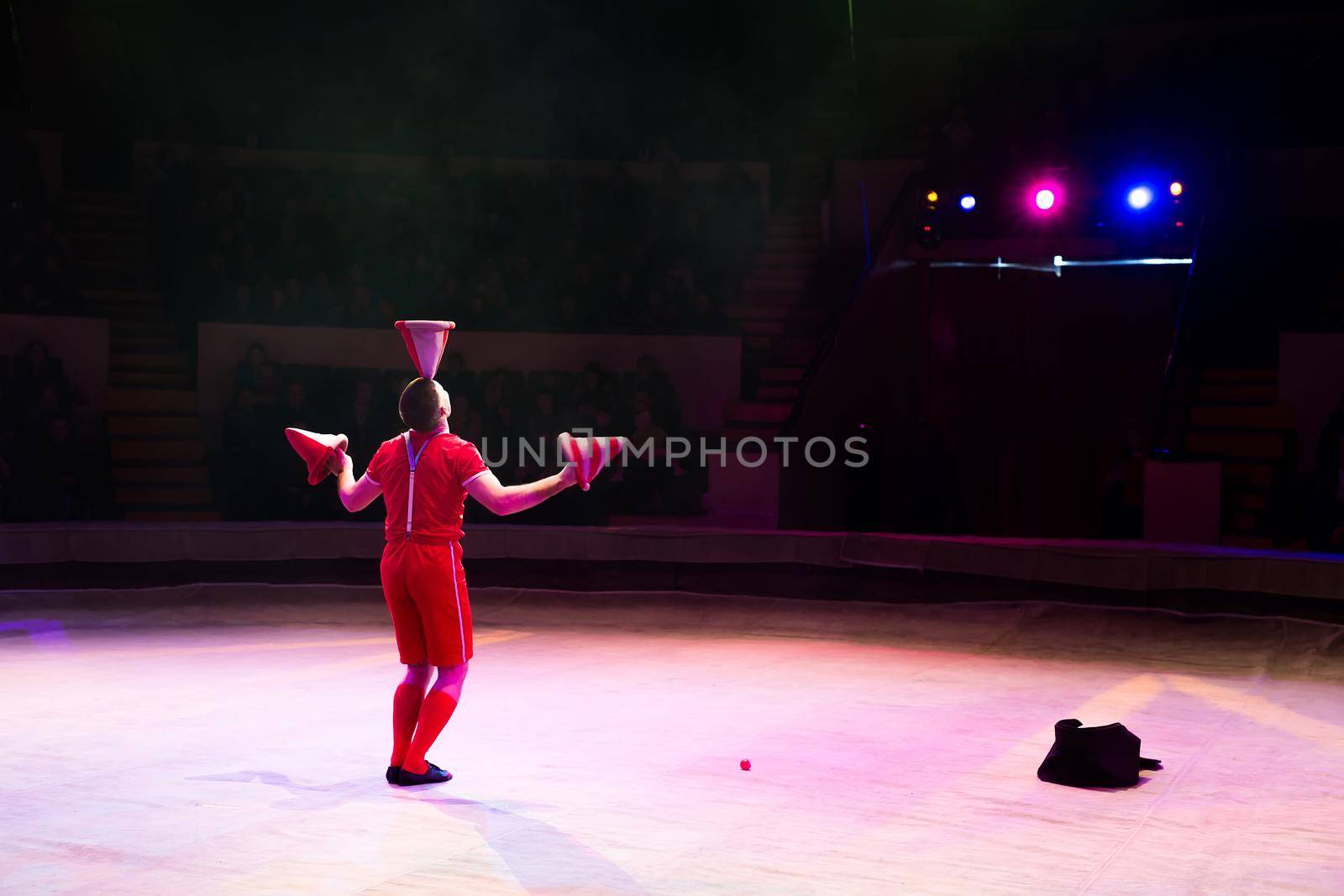 Acrobat performs a difficult trick in the circus by StudioPeace