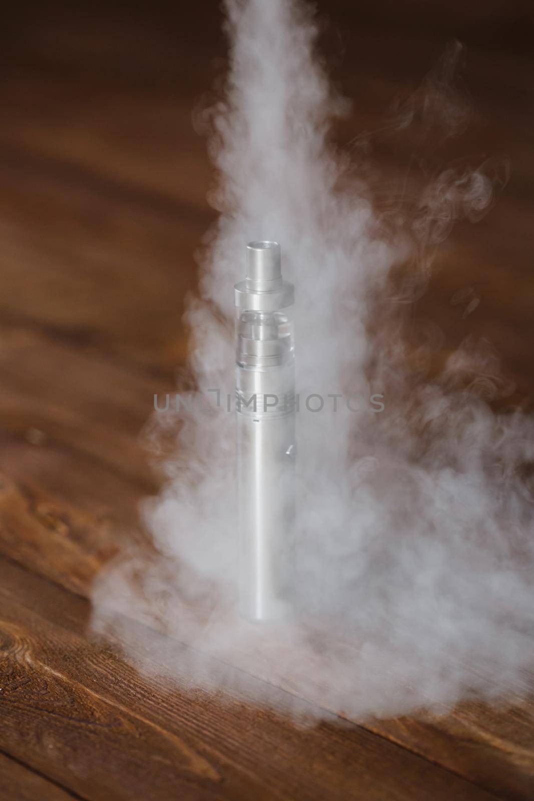 Electronic cigarette on a wooden table. Smoke.