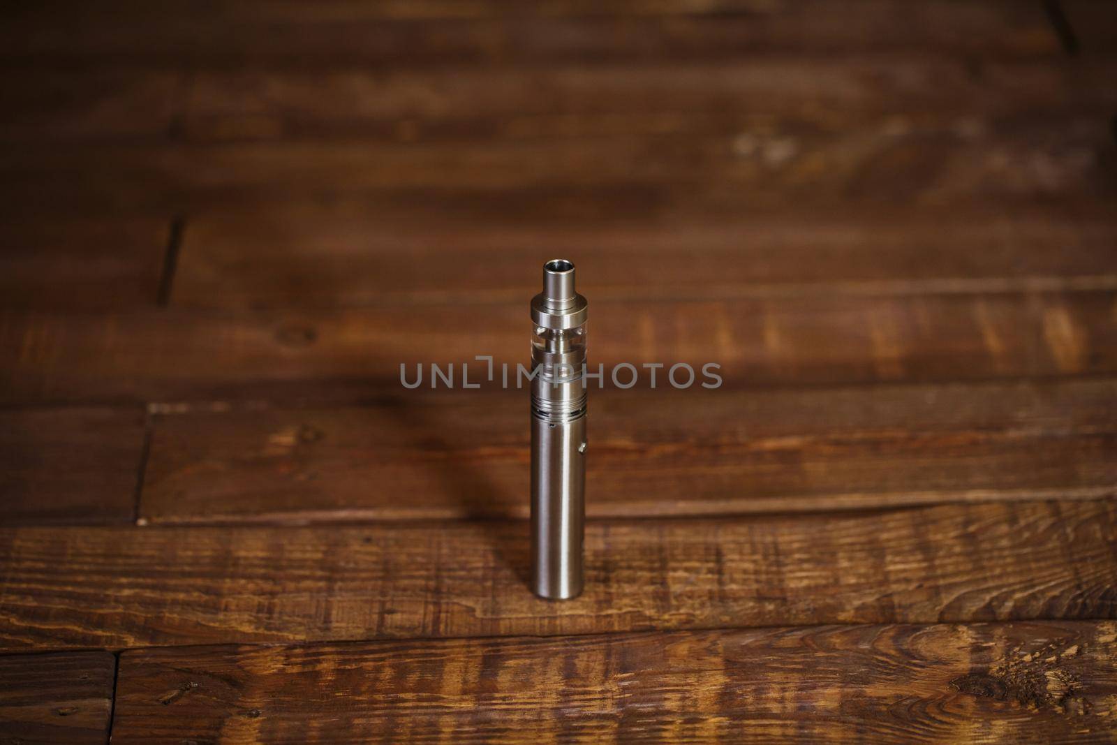 Electronic cigarette on a wooden table. Smoke.