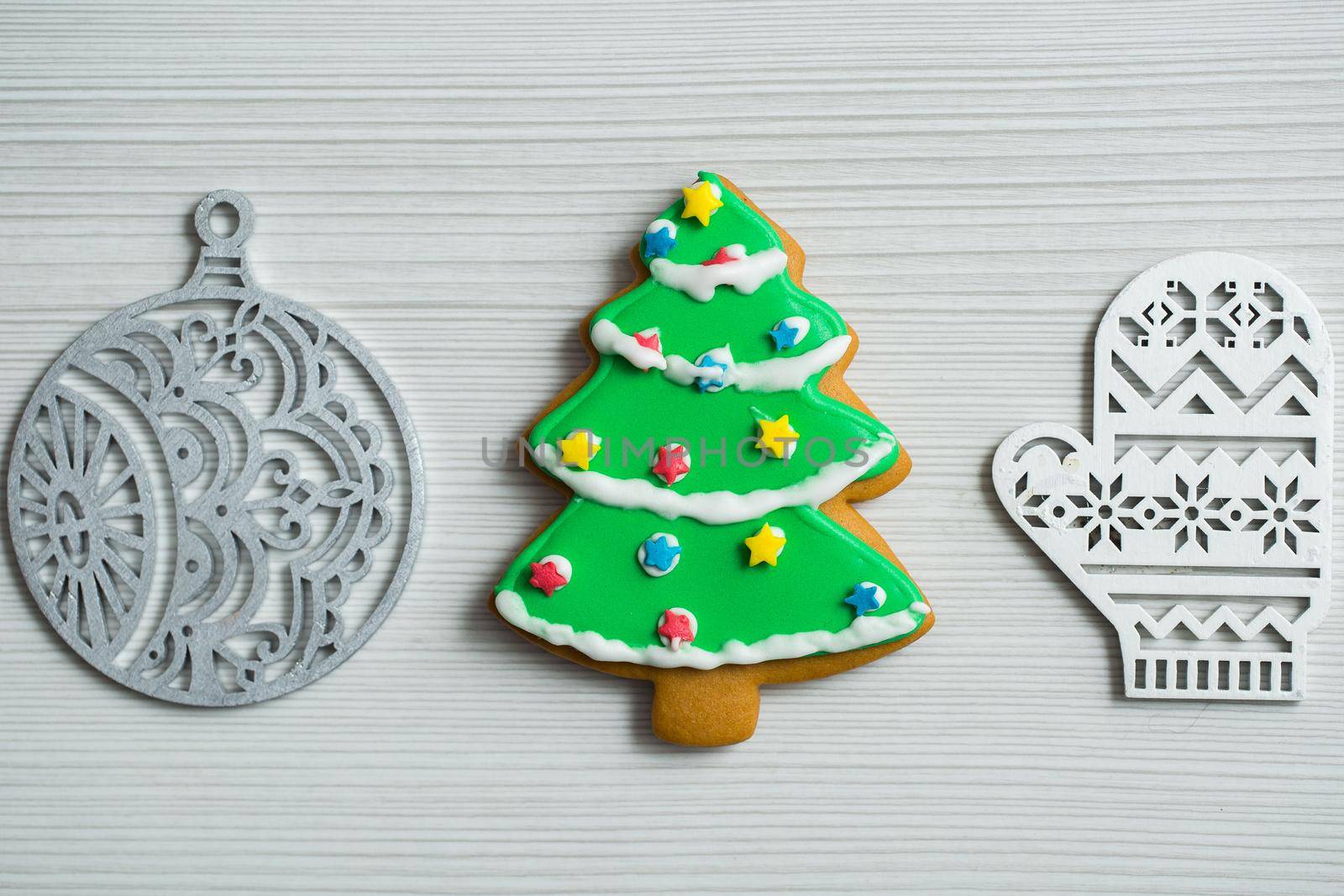 Christmas, new years decor on a wooden white background. Gingerbread mitten, a ball, lump, nut by StudioPeace