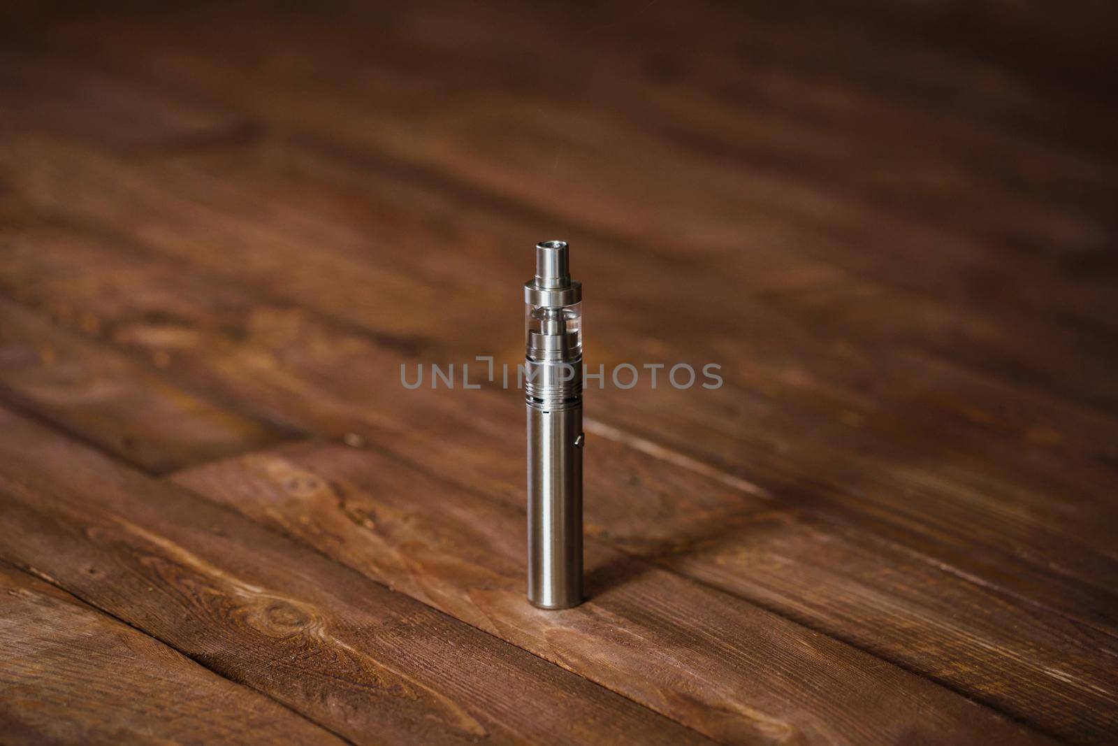 Electronic cigarette on a wooden table. Smoke by StudioPeace