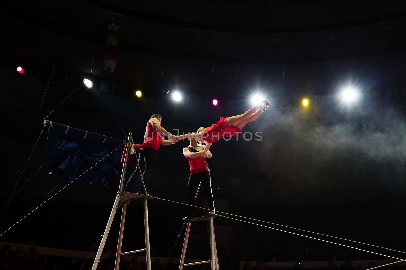 Bright performance of acrobats under the dome of the circus