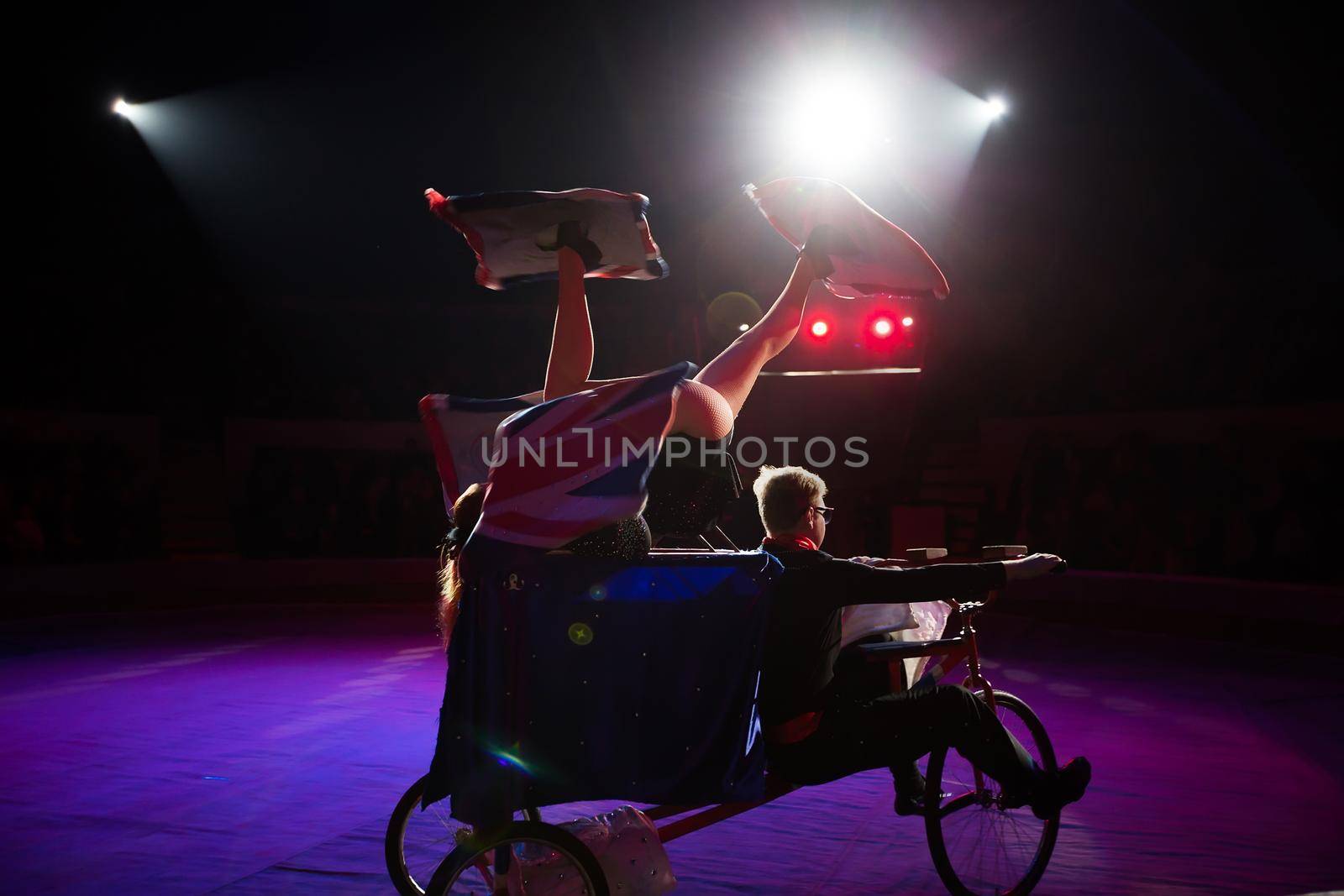 A juggler on a bicycle under the dome of the circus