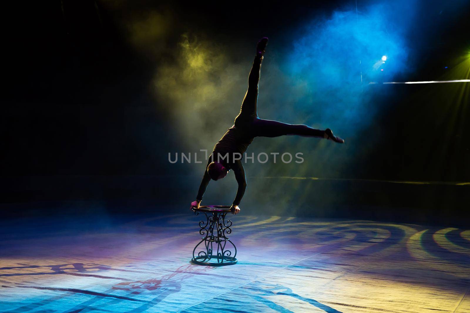 Acrobat performs a difficult trick in the circus.