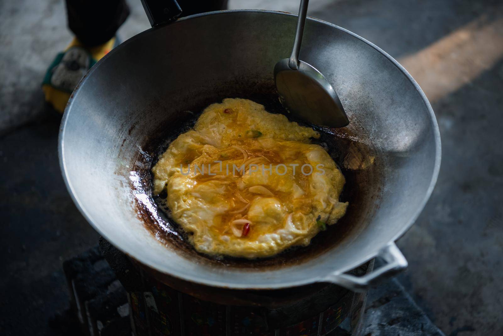 Thai style omelet is a Thai food make from egg cooking in pan with oil in Thai street food restaurant, healthy food concept