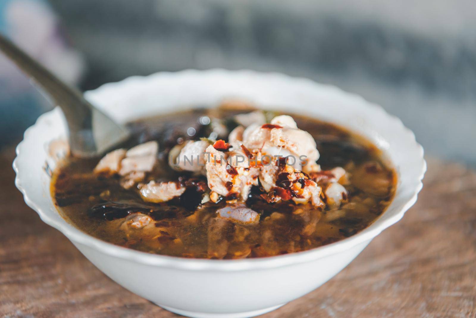 Hot and sour meat soup (Tom Yum) pork or chicken for sale at Thai street food market or restaurant in Thailand